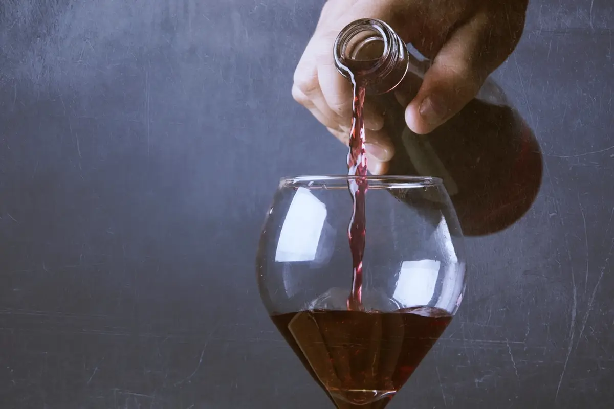 Rode wijn wordt in een glas geschonken